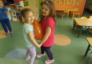 dziewczynki tańczą z balonem pomiędzy sobą